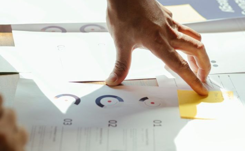 Mano organizando una planificación visual sobre documentos de trabajo.